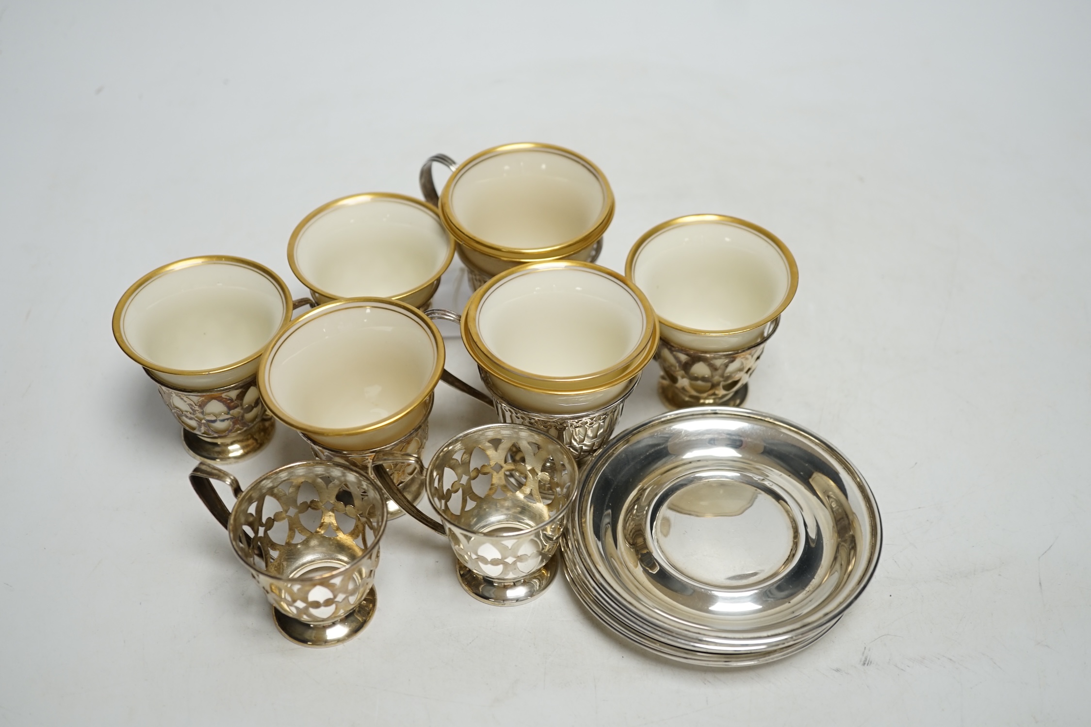 A set of six Limoges Lenox coffee cups with sterling holders and saucers and a pair of larger similar cups with holders and saucers.